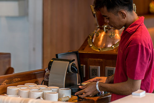 A Oceanic's crew using a espresso coffee machine