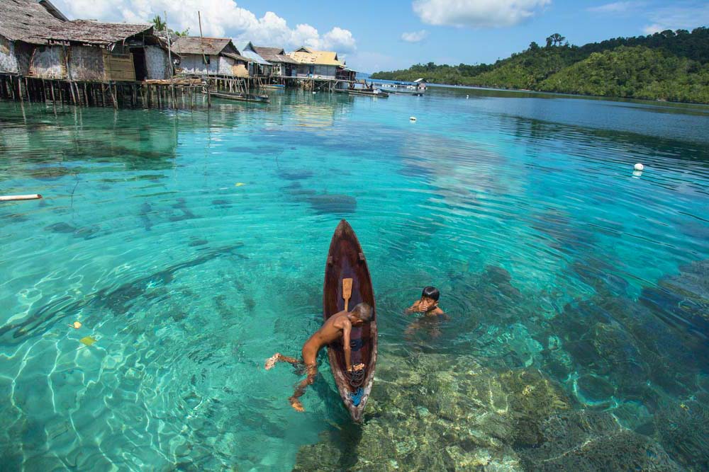 Bajau kids on canoes in the Togeans