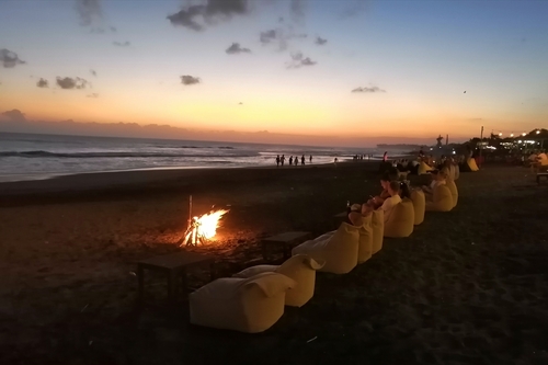 Bonfire in front of the ocean at sunset in Canggu