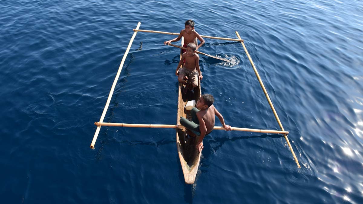 Kids on canoes at Pulau Serbete, Forgotten Islands of Indonesia
