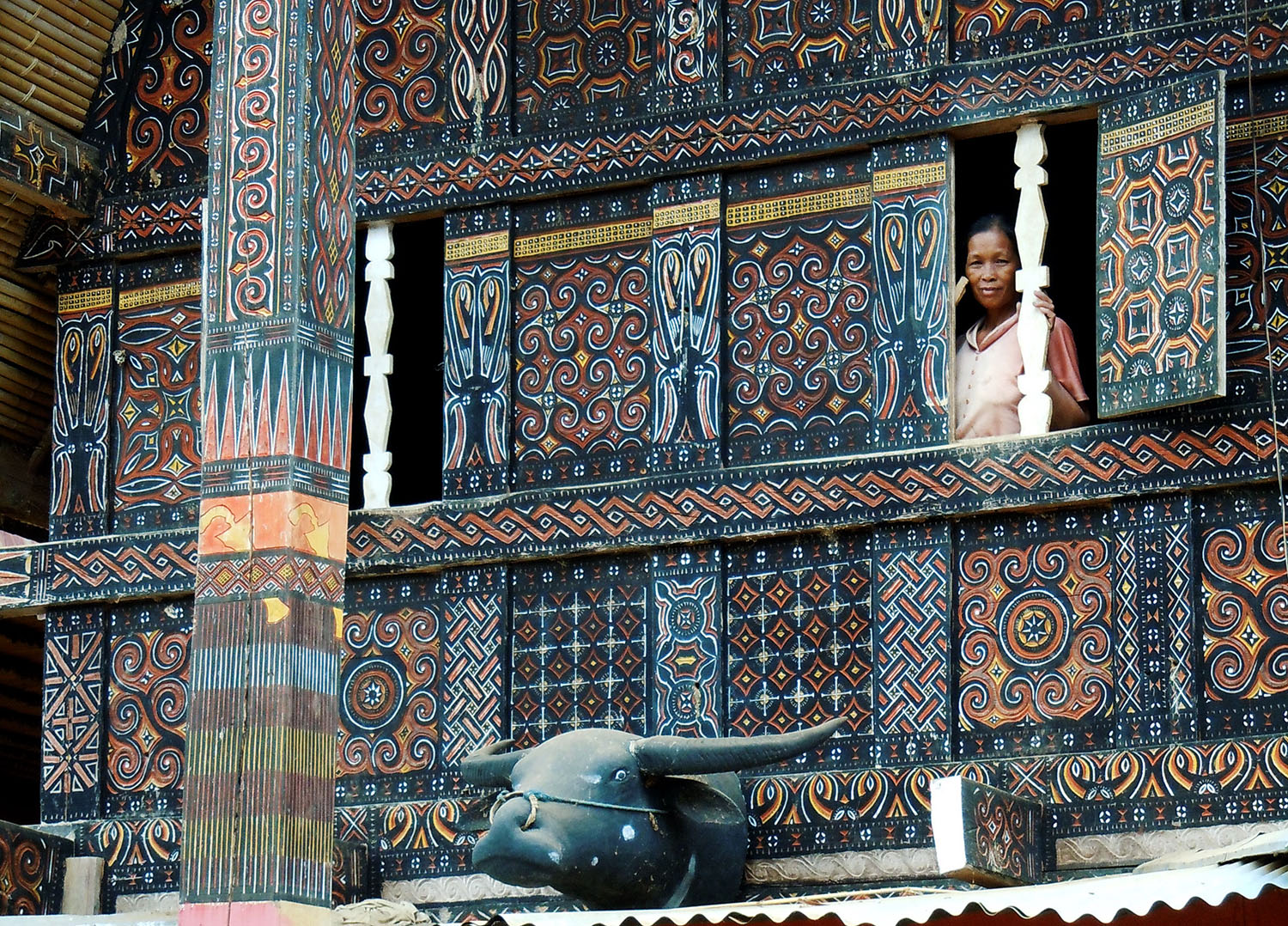 Tongkonan house, wood carving with symbolic designs and buffalo head

